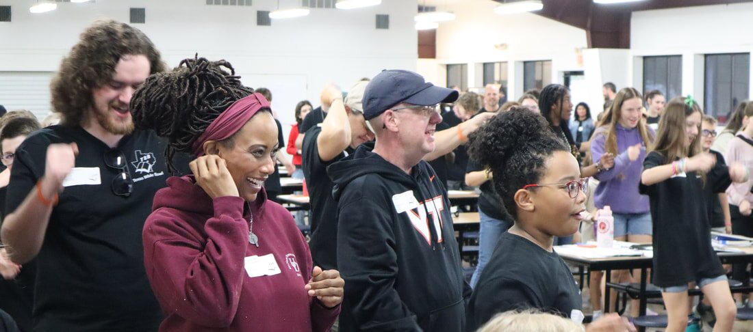 Coaches and students laughing and dancing together between rounds